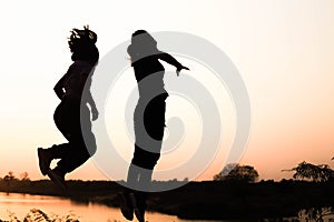 Silhouette of a family comprising a father, mother and two children happy family the sunset.Concept of friendly