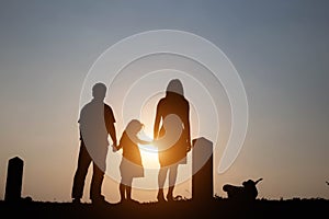 Silhouette of a family comprising a father, mother and two children happy family the sunset.Concept of friendly