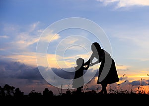 Silhouette of a family comprising a father, mother and two children happy family the sunset.Concept of friendly