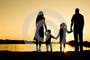 Silhouette family, including his father, mother and two children in the hands of