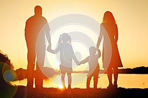 Silhouette family, including his father, mother and two children in the hands of