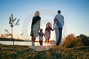 silhouette family, including his father, mother and two children in the hands of