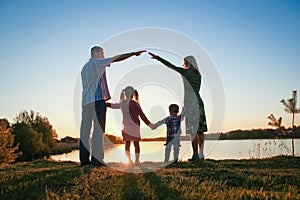 silhouette family, including his father, mother and two children in the hands of