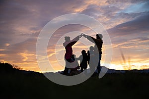 Silhouette of a family outside under evening sky