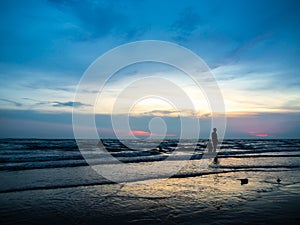 Silhouette of family playing on the beach in the summertime.