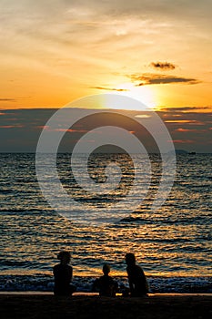 Silhouette of Family playing on the beach at sunset