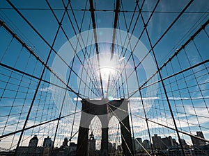 The silhouette of the famous Brooklyn Bridge, the sun at its zenith shines above its pillars. One of the most famous