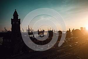 Silhouette of famous Hamburger Landungsbruecken with commercial harbor and Elbe river in late evening sunset light, St