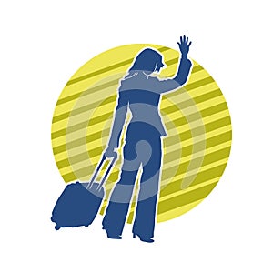 Silhouette of a fashionable female carrying a wheeled luggage travel bag. Silhouette of a business woman doing business trip