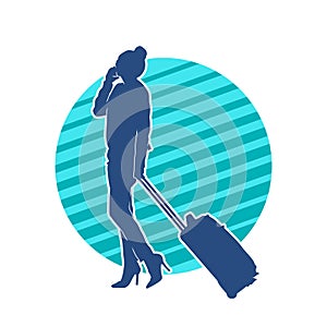 Silhouette of a fashionable female carrying a wheeled luggage travel bag. Silhouette of a business woman doing business trip