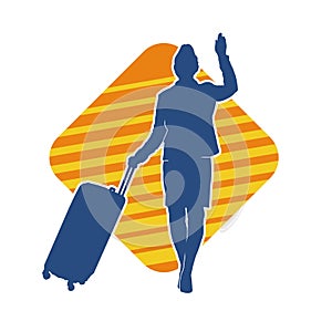 Silhouette of a fashionable female carrying a wheeled luggage travel bag. Silhouette of a business woman doing business trip