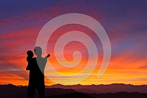 Silhouette of Father and child watching sunrise