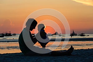 Silhouette of father and daughter on sunset beach