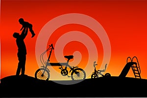 Silhouette of father have fun with his children, slide, tricycle and folding bike at park when sunset or sunrise