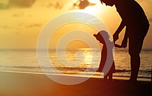 Silhouette of father and little daughter at sunset