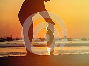 Silhouette of father and little daughter walk at sunset