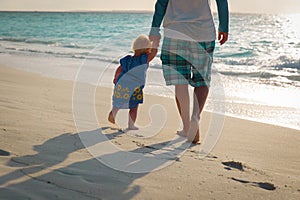 Silhouette of father and little daughter walk at sunset