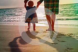 Silhouette of father and little daughter walk at sunset