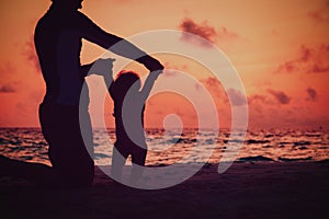 Silhouette of father and little daughter walk at sunset