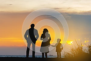 Silhouette of Father mother and son playing at beach evening sunset background, Happy family concept