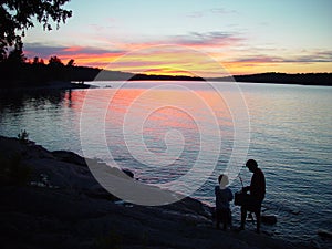 Silhouette of father and son fishing
