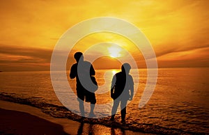 Silhouette of Father and son took a walk on the beach. photo