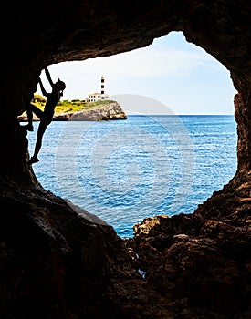 Silhouette of a female athlete climbing in a cave.