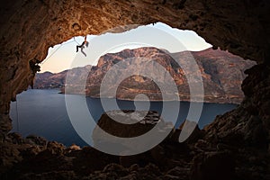 Silueta de una mujer la roca alpinista sobre el acantilado en cueva 