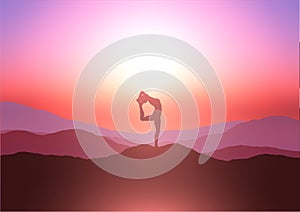 Silhouette of a female in a yoga pose against a sunset sky