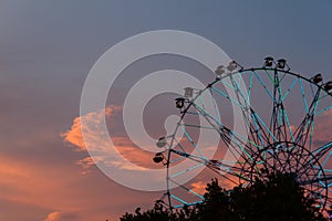 Silhouette of ferris wheel at sunset at county fair.