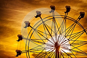 Silhouette of ferris wheel at sunset at county fair