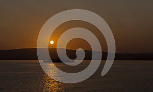 Silhouette Ferry Under Setting Sun