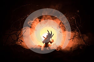 Silhouette of fire breathing dragon with big wings on a dark orange background. Horror image