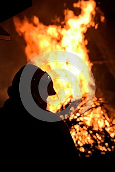 The silhouette of a firefighter putting out a fire