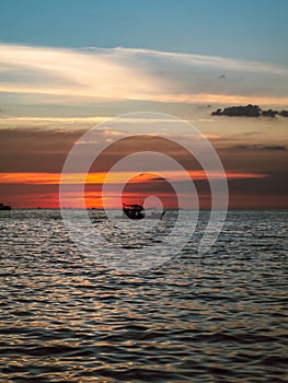 Silhouette of a fisher boat at sunset at the sea in Vietnam