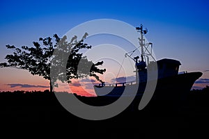 silhouette of a fisherboat in sunset