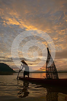 Silhouette fisherman of Bangpra Lake in action when fishing.