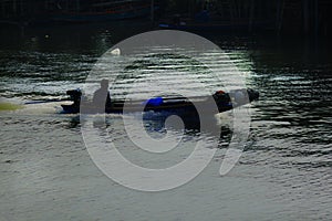 Silhouettes of boats fishing in running water.