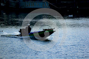 Silhouettes of boats fishing in running water.