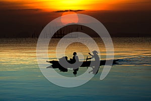 silhouette of the fisherman in fishing boat on the lake