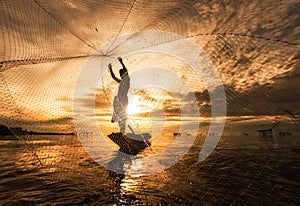 Silhouette Fisherman Fishing Nets on the boat. photo