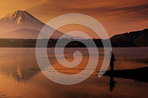 Silhouette fisherman fishing at Shoji lake with mount Fuji view reflection at dawn with twilight sky in Yamanashi