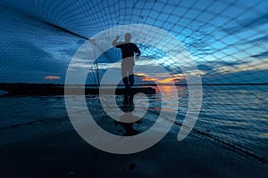 Silhouette of fisherman at the lake in action