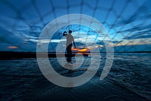 Silhouette of fisherman at the lake in action