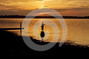 Silhouette fisherman of Lake in action when fishing.