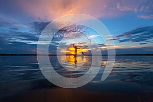 Silhouette fisherman with net at the lake