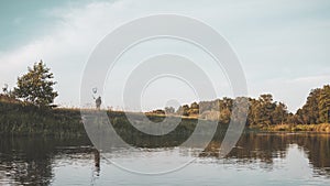 Silhouette of a fisherman on the river bank