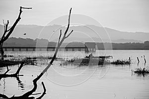 Silhouette fisherman on wooden  boat over bang phra reservoir