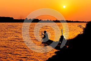 Silhouette of fishermen catch fish in the canal