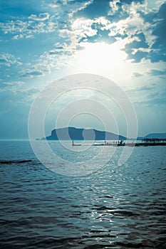 Silhouette of fishermen fishing at sea outdoors on sunset. Summer leisure, sport, holiday concept. Vertical image